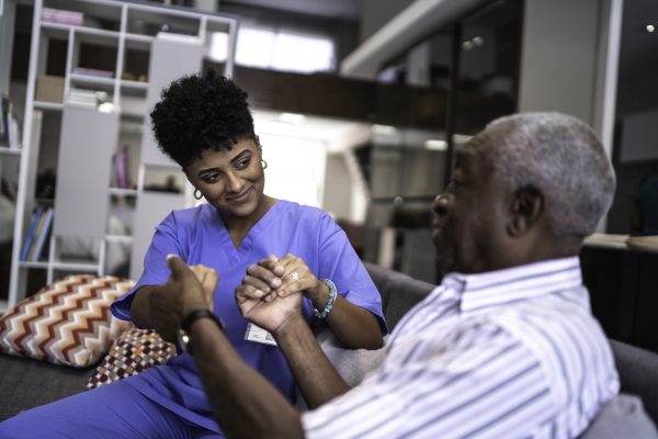 Female nurse taking care of a senior man at home